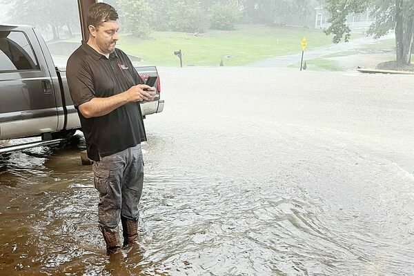 Rural Rapid Response ambulance service owner Tyler Blalock watches as flood waters rise at his business at the corner of Walnut and Second streets in downtown Meadville Thursday, June 30.