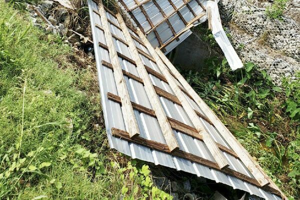 The porch roof from Sullivan's Kitchen and Produce at the corner of Second and Walnut streets in Meadville lies in a nearby road-side ditch after thunderstorms on Wednesday afternoon damaged the front of the building. (Photo by Duane Simpson)